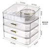 Design transparent avec couvercle supérieur, plateau tournant et 3 tiroirs.