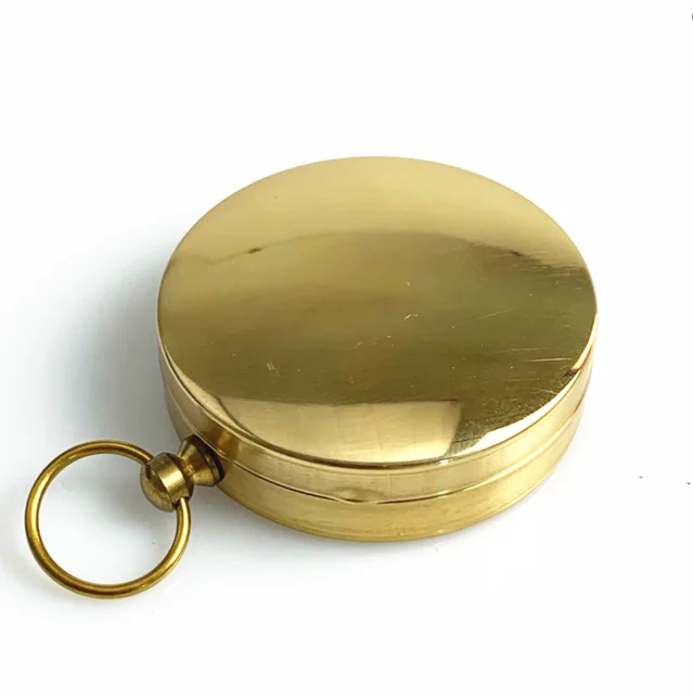 a pure copper flip compass with a key ring and a luminous dial