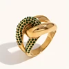 Anillo dorado con circonita contrastante anudada en verde.