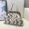 Bolso dumpling con diseño de ondas beige.