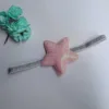 Cerchietto per capelli rosa con grande stella a cinque punte.