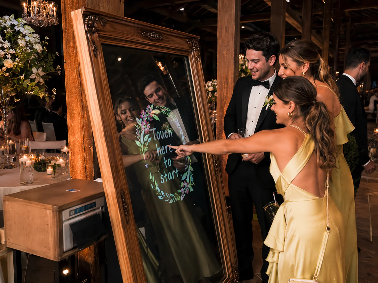 Guests using a vintage wood mirror photo booth at a high-end wedding reception