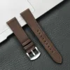 Boucle argentée, bracelet marron foncé.