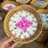 Panier tressé en coquillage, motif floral rouge doré.