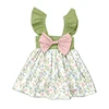 Vestido de niña con estampado de tulipanes mixtos, lazo rosa y hombros descubiertos en verde.