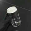 Botella transparente con tapa blanca.