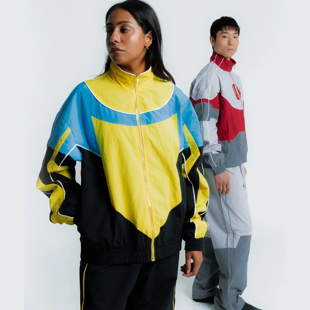 Trendy fabriksproduceret vintage-træningssæt i farveblokke af nylon – 90’ernes streetwear med ståkrave og lynlås – vindjakke i to-delset sæt – unisex – OEM