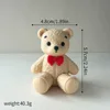 014-orso di peluche di colore chiaro in posa seduta-rosso