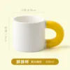 White cup with yellow handle