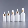 Botella blanca con tapa de oro