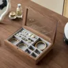 Caja de joyería premium de nogal gris con tapa de cristal.