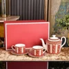red A pot with 2 cups and saucers