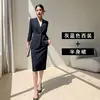 Veste de costume bleu-gris avec jupe superposée.