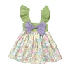 Vestido de niña con estampado floral vintage, lazo morado y hombros descubiertos.