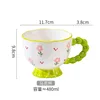 Tazza da colazione con manico verde con fiori rosa e manico a forma di cuore