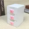Three layers of white flowers with three bows
