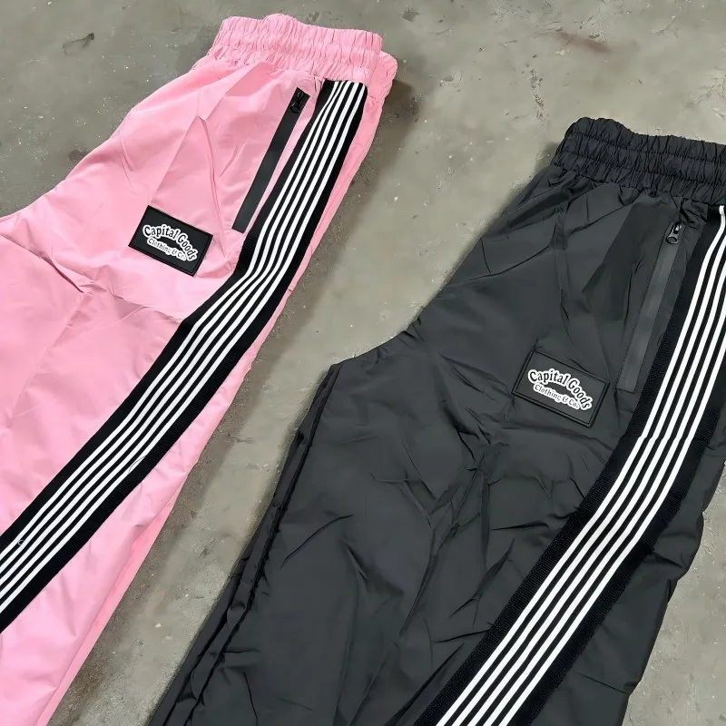 Przeciwiatrzne spodnie sportowe w stylu streetwear z nylonu, proste, luźne, z paskami, męskie, rozszerzające się ku dołowi, z nylonu, przeciwiatrzowe, dresy treningowe dla mężczyzn