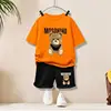 Grande orso dorato#t corta arancione + pantaloncini neri