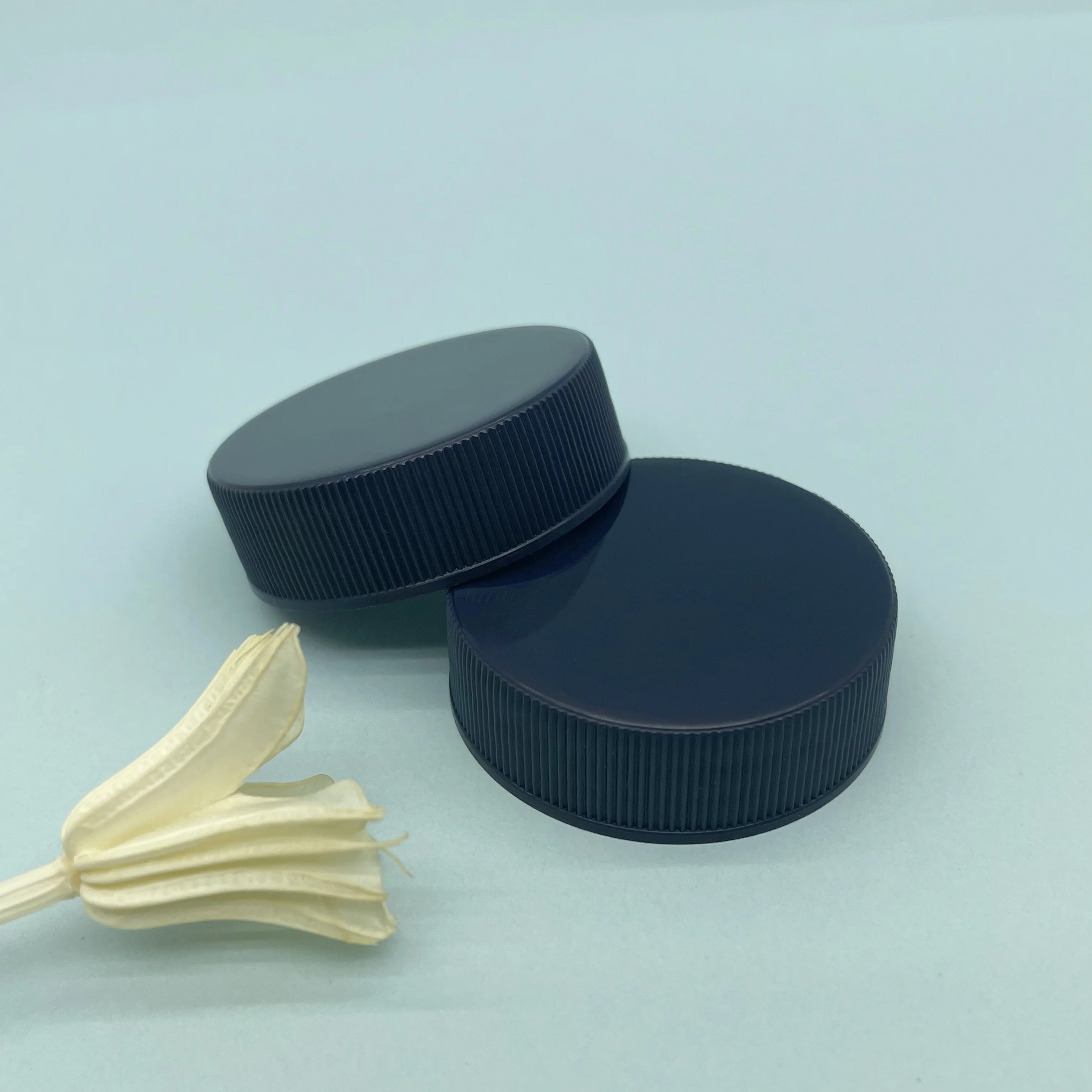 Tappo a vite a coste in plastica nera da 38 mm con guarnizione per bottiglie di imballaggio cosmetico