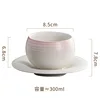 Taza y platillo rosa de 280 ml, sin asa y con forma de huevo.