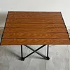 Mesa plegable pequeña con diseño de vetas de madera.