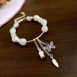 Elegant Bracelet with Light Green Jade Beads Butterfly Bell Feather Charms Unique Handmade Jewelry for Women Daily Wear Gifting