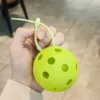 Yellow-green molded ball with adhesive fastener