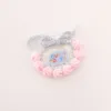 Bavoir à fond blanc, bordure rose et lettrage bleu