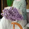 Manta blanca con flores moradas.