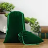 Sac en velours vert gazon avec cordon de serrage.