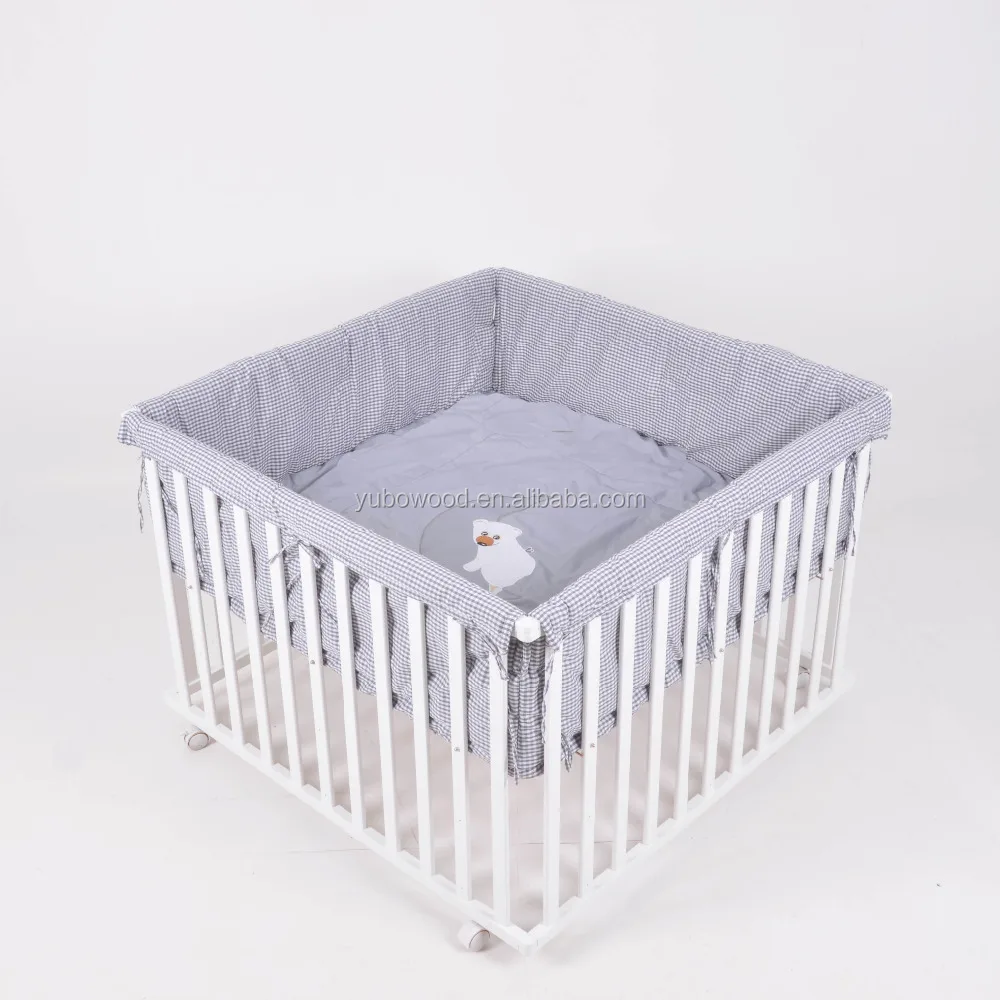 white wooden playpen
