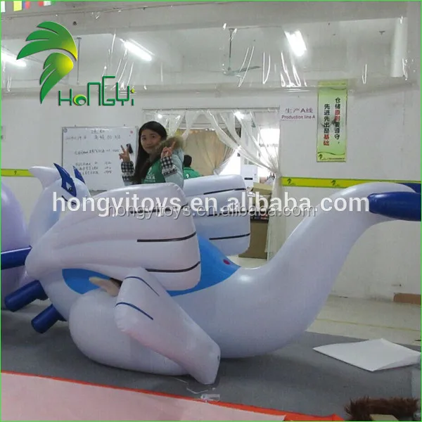 Giant chubby shiny inflatable lugia-looking dragon, standing above