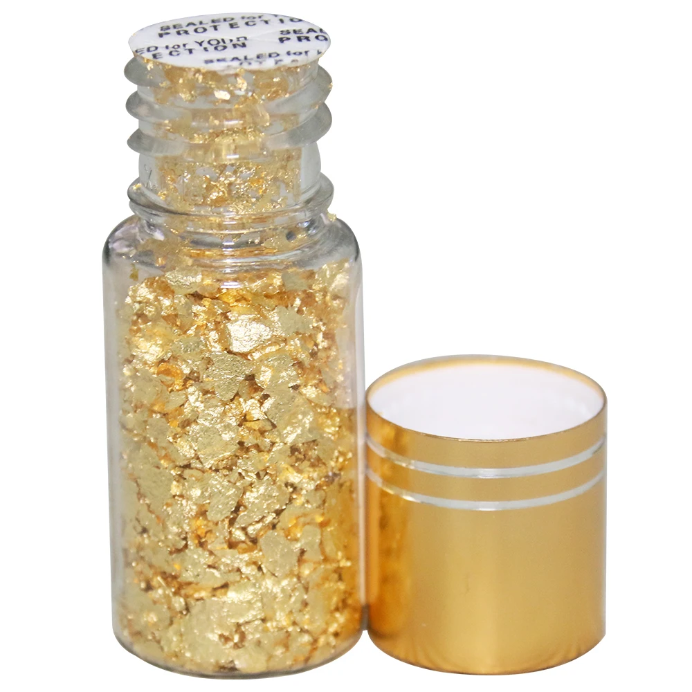 Top View of Edible Gold Leaf Flakes in Glass Jar Stock Photo