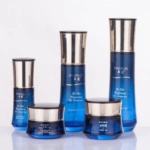 Luxurious Streamline Blue Set Glass Bottle Cosmetic Packaging with 30g 50g Glass Jar 14K Gold Electroplating Lid
