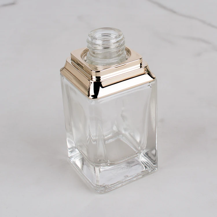 Cosmetic empty 30ml glass bottles thick bottom with gold anodized shoulder sleeve foundation packaging manufacture