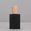 Botella de perfume negro con tapa de madera