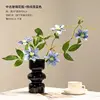 Black vase with blue clematis