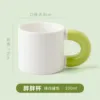 White cup with green handle