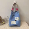 Sac à main bleu avec motif de chien à grosse tête en face latérale.