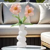 Two orange pebble ceramic vases adorned with blooming tulips