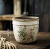 Maceta de 1315 cm con flores rosas y orificios de drenaje