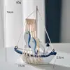 Piccola imbarcazione con ancora in ferro a forma di pesce