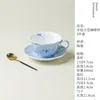 Taza de café azul degradado pintada a mano con combinación de flores y mariposa rui.