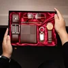 Set da 7 pezzi: portafoglio, cintura, orologio, portachiavi, fibbia, penna, occhiali da sole