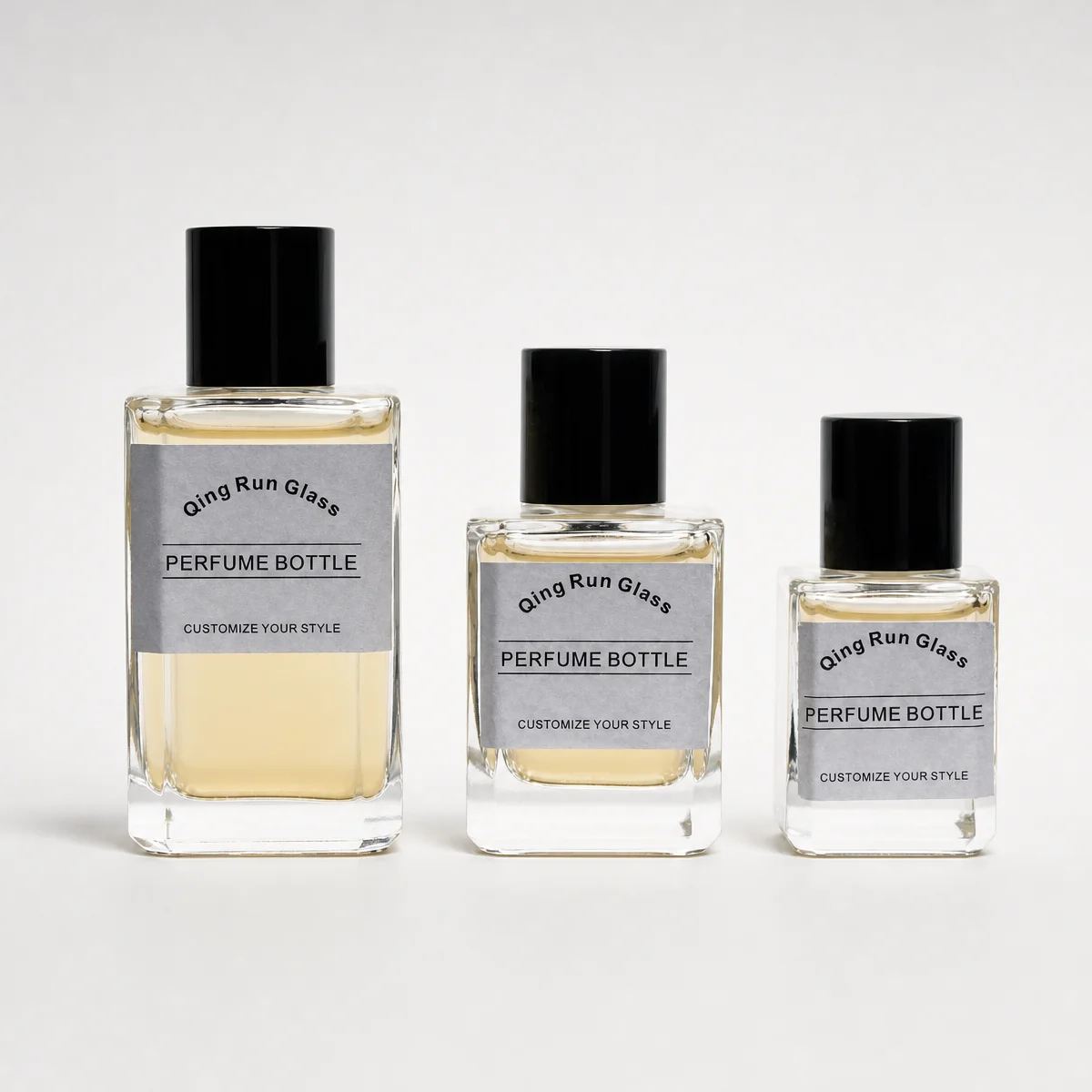 Clear Square Glass Perfume Bottles with Black Cylindrical Caps and Printed Labels