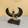 Déesse à genoux en or noir étalant ses ailes
