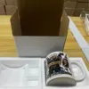 Taza blanca con logo grande de caja blanca.