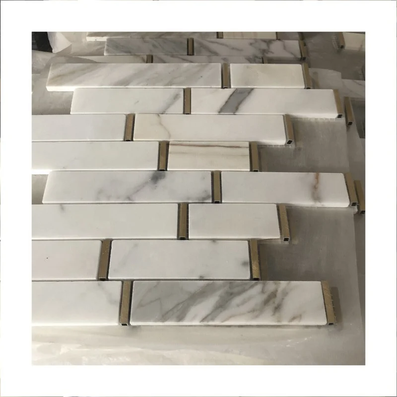 แผ่นตกแต่งด้านหลังอ่างล้างหน้าในห้องน้ำ ทำจากหินอ่อนสีขาวคาลาแคตตา พร้อมงานศิลปะโลหะบนผนังทรงทองเหลือง