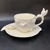 Taza y plato con diseño de rosa 3D en blanco.