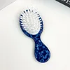 Cerdas texturizadas de jabalí azul con dientes de peine blancos.